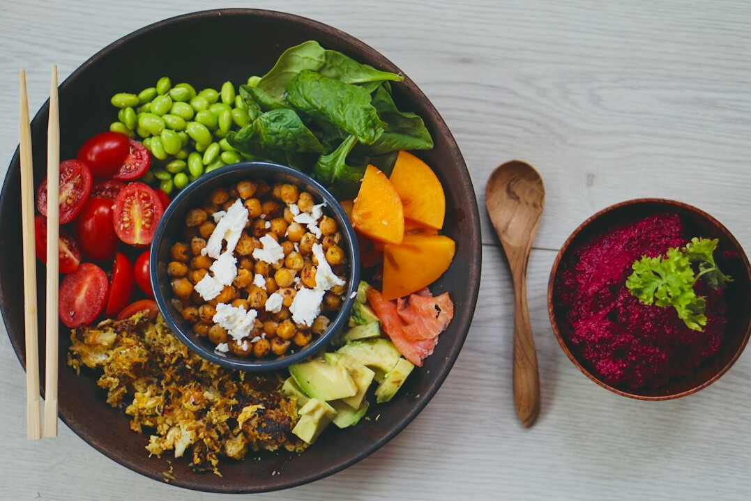 Overhead view of a healthy colorful bowl of vegetables and grains on a table